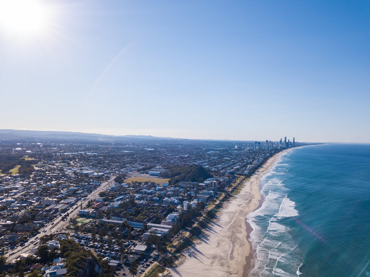 Stunning aerial view of Gold Coast, Queenslands coastline stretching along the ocean in daylight.